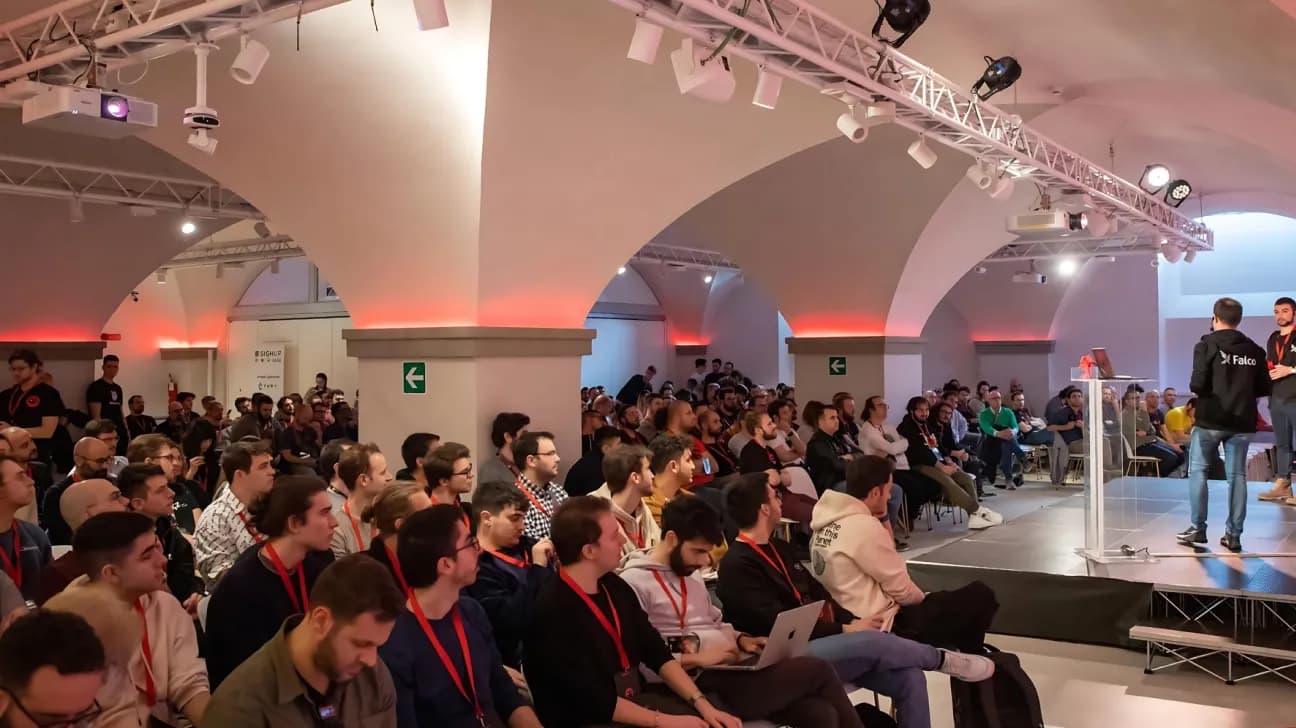 Persone che partecipano a un evento tecnologico in una grande sala riunioni con archi presso Nana Bianca a Firenze. Lo spazio è dotato di un'illuminazione moderna e di un allestimento professionale, ideale per eventi di coworking e uffici condivisi, che mette in risalto un ambiente collaborativo per startup e professionisti.