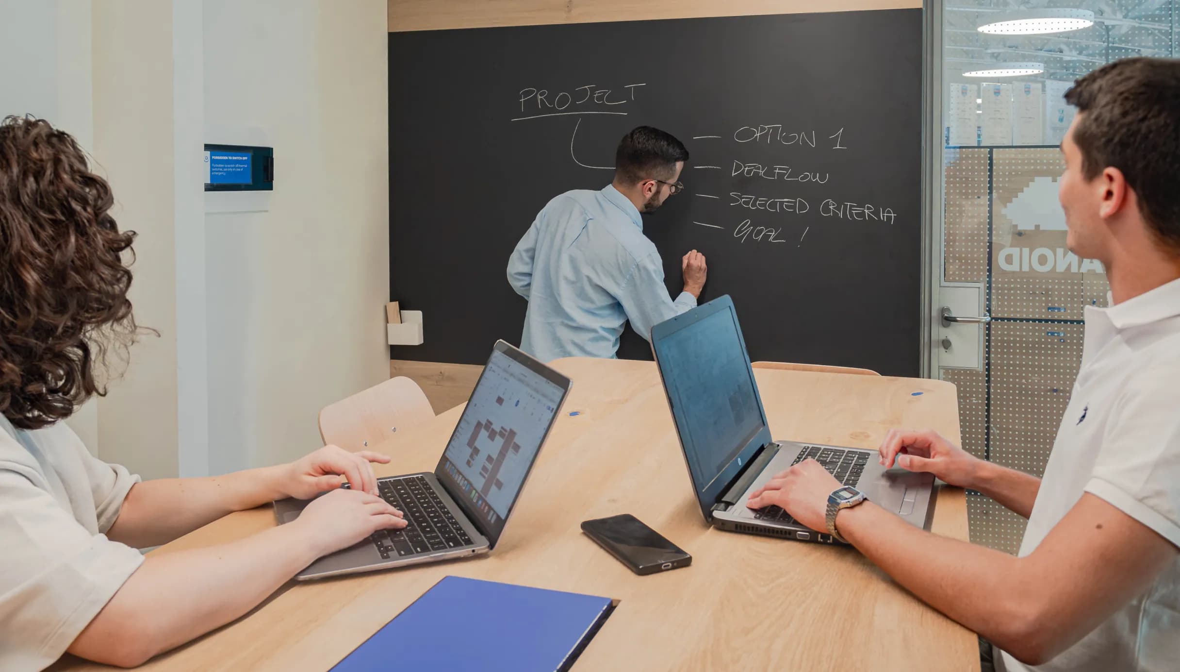 Un team di professionisti lavora in una sala meeting di Nana Bianca, con una lavagna per annotare strategie e un ambiente stimolante per sessioni di brainstorming.